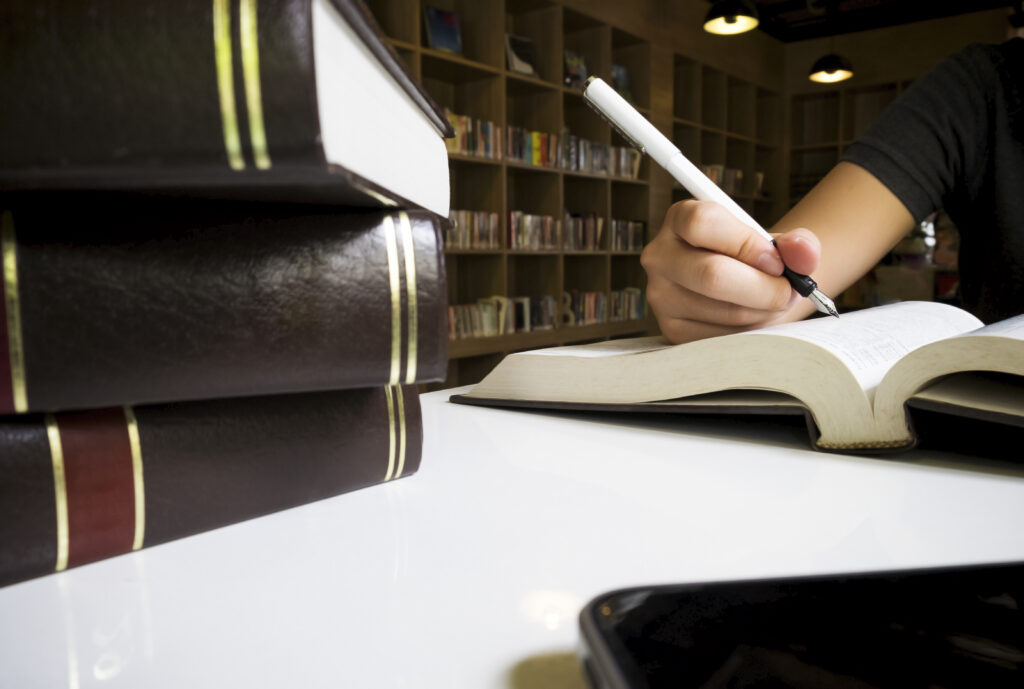 Woman reading book in library.